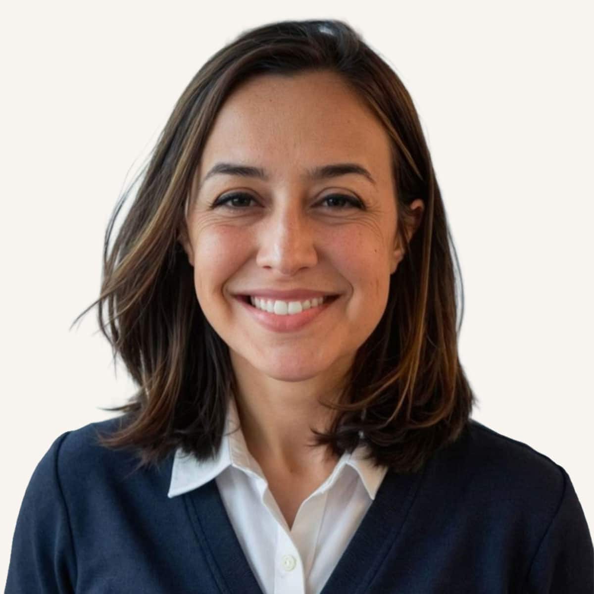 A woman with shoulder-length brown hair smiles at the camera. She is wearing a white collared shirt under a dark sweater. The background is plain and light-colored.